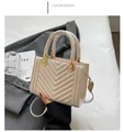 Dettaglio borsa in pelle bianco crema con manico intrecciato e trapuntatura a V - Bianco