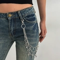 Dettaglio di ciondoli a stella in argento multistrato e nappe hip-hop su pantaloni denim - Stile Stella Multistrato (01990)