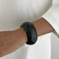 Detail of wide black resin bracelet with shimmering glitter finish on white suit sleeve - Starry Glitter Resin Black Silver Style (0087)