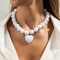 Collier de perles blanches avec pendentif cœur en résine porté par un mannequin - Blanc