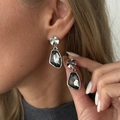Close-up of silver textured earrings with dark grey irregular faceted gems on a model - Silver Gray Irregular (03891)
