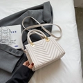 Minimalist cream white crossbody bag with V-shaped pleated texture and woven handle - Off-white