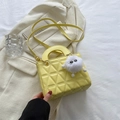 Bright yellow quilted crossbody bag with top handle and cute monster plush charm detail - Yellow