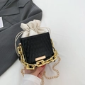 Minimalistische zwarte bucket bag met golftextuur, crème voering en gouden kettingriem - Zwart