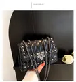Detail of black quilted crossbody bag featuring silver square studs and metal chain strap - Black