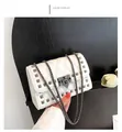 Detailed view of white quilted crossbody bag with metal studs and chain strap - White