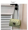 Close-up of green quilted shoulder bag featuring dark metallic studs and chain strap - Green