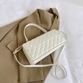White quilted faux leather crossbody bag with gold hardware on beige blazer - White
