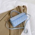 Light blue quilted shoulder bag with chain strap and handle on a beige blazer - Blue