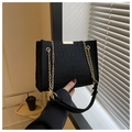 Detail of black crocodile texture felt shoulder bag with golden chain and metal trim - Black