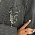 Dettaglio di catene d'argento multistrato con ciondoli a cuore e stella su risvolto di blazer - Bicolore Oro e Argento