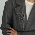 Détail d'une broche à pompons argentée avec perles et cœur sur revers de veste - 01 Blanc K (0349)