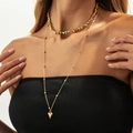 Gold layered necklace featuring irregular beads and a polished heart pendant on a model - Layered Smooth Heart Style (06808) / Gold