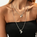 Silver layered necklace set with heart coin pendant and white pearls on a model - Artificial Pearl Coin Layered Style (06804) / Silver