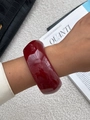 Detail van een brede wijnrode hars armband met glanzende afwerking gedragen om de pols - Wijnrode brede harsarmband met marmerpatroon (02657)
