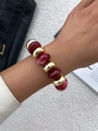 Detailopname van rode harskralen en gepolijste gouden kralen op retro armband - Armband met rode wolkenkralen en gouden gepolijste kralen (0122)