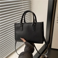 Minimalistische schwarze Zylindertasche mit Faltenstruktur und doppelten Tragegriffen - Schwarz