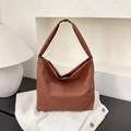 Dettaglio della trama in pelle intrecciata marrone su una borsa hobo capiente - Marrone