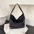 Dettaglio della borsa tote in pelle nera intrecciata che mostra la trama di lusso - Nero