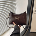 Elegant dark brown shoulder bag with gold bow buckle and glossy leather finish - Brown