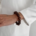 Dettaglio di perline in acrilico tartarugato su bracciale elastico indossato al polso - Bracciale con perline leopardate nero marrone