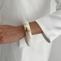 Nahaufnahme eines minimalistischen Harz-Armreifs mit Marmormuster an weißem Anzug - Marmorweiß Verdickter Stil (0153) / Gebrochenes Weiß