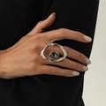 Detail eines silbernen Wellenrings mit facettiertem dunkelgrauem Ovalstein am Finger - Welliger Hohler Ovaler Edelsteinstil (00962)