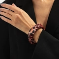 Close-up of leopard print resin bangle on black suit sleeve showing polished texture - Leopard Red Brown