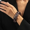 Close-up of a wide leopard print resin bangle on a black suit sleeve for a vintage look - Leopard Dark Coffee