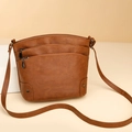 Minimalist brown bucket bag with triple zippers and multi-layer storage on white stand - Brown