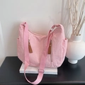 Borsa tote in velluto a coste rosa con tracolla larga e doppie cerniere su un tavolo - Rosa