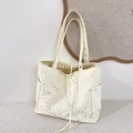 Detail of white canvas tote bag featuring shiny silver star prints and side pockets - Off White