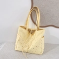 Detail view of yellow canvas tote bag with silver star prints and drawstring closure - Yellow