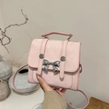 Pink mini crossbody bag featuring a silver metal butterfly knot and textured fabric finish - Pink