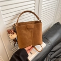 Vintage brown suede bucket bag with plush bear charm on a minimalist leather sofa - With Pendant / Brown
