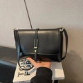 Close-up of black vintage faux leather bag with gold buckle and matte texture - Black