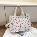 Detail showing white corduroy tote bag with red strawberry print and front pockets - Strawberry Embroidery Beige