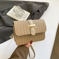 Chic beige woven square crossbody bag with gold buckle held by a model in a grey suit - Khaki