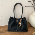 Detalle de bolso tote de ante negro con hebilla decorativa y colgante de cuentas de madera - Con Colgante / Negro