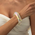 Dettaglio di un grosso bracciale in resina iridescente con effetto olografico sul polso - AB Colorato (03031)