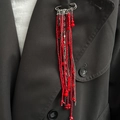 Beaded brooch with vibrant red crystal tassels and silver chain on a dark grey coat - Silver Red (00329)