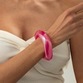 Dettaglio di un ampio bracciale in resina rosa traslucida con finitura lucida al polso - AB Magenta (03031)