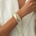 Bracciale rigido in resina perlata con riflessi laser colorati al polso di una modella - AB Colorato (03032)