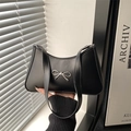 Minimalist black leather underarm bag featuring a metallic silver bow accent - Black