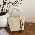 Borsa a secchiello beige in ecopelle con ciondolo in legno e tracolla regolabile - con portachiavi / Bianco