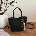 Elegante borsa a secchiello nera opaca con ciondolo in legno colorato su tavolo - con portachiavi / Nero