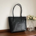 Dettaglio della trama intrecciata nera e della pregiata fattura di una borsa shopper - Nero