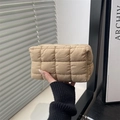 Quilted lattice makeup bag in beige nylon fabric held by hand in natural lighting - Khaki