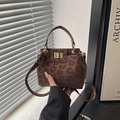Macro shot of faux suede handbag featuring leopard print and a gold rectangle metal clasp - Brown