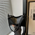 Bolso tote minimalista de cuero negro con asa anudada y detalles metálicos dorados - Negro